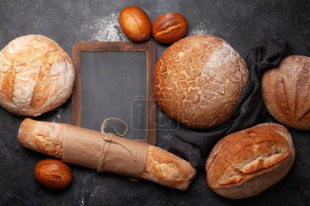 Téléchargez les photos : Différents types de pain sur table en pierre. Vue du dessus plat avec espace de copie - en image libre de droit