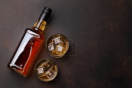 Foto de Botella de whisky escocés y vasos en la mesa de piedra. Con espacio para copias. Vista superior plano laico - Imagen libre de derechos