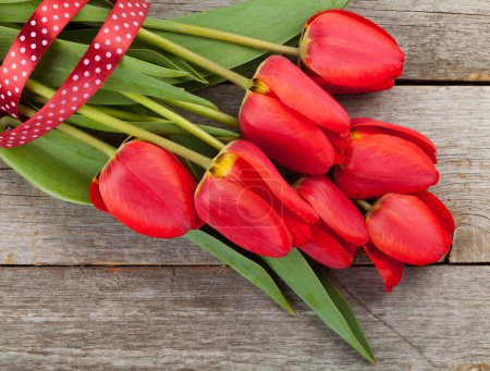 Foto de Ramo de flores de tulipán rojo en mesa de madera con espacio para copiar. Vista superior plano laico - Imagen libre de derechos