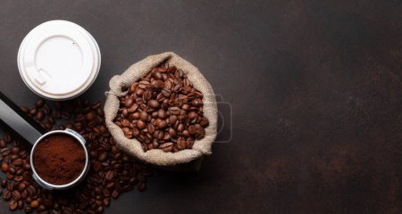 Téléchargez les photos : Café frais dans une tasse à emporter, grains de café torréfiés et café moulu dans le porte-filtre. Vue du dessus plat avec espace de copie - en image libre de droit