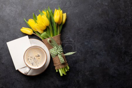 Photo for Yellow tulip flowers bouquet and coffee cup on stone table. Top view flat lay with copy space - Royalty Free Image