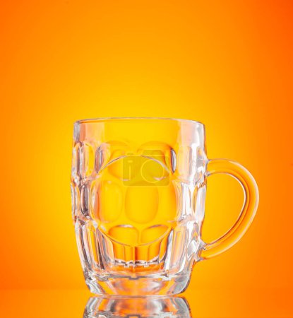 Photo for Empty beer glass in front of yellow background. Studio shot - Royalty Free Image