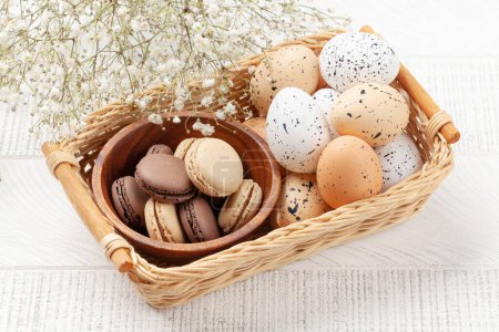 Photo for Easter greeting card with easter eggs and macaroons in basket - Royalty Free Image