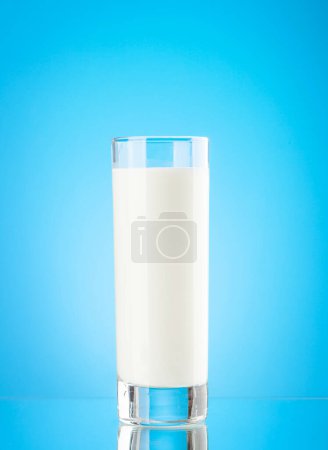 Foto de Vidrio de leche sobre fondo azul. Productos lácteos - Imagen libre de derechos