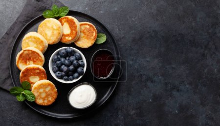 Photo for Cottage pancakes with berry jam, sour cream and berries. Top view flat lay with copy space - Royalty Free Image