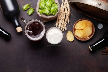 Photo pour Tasse à bière allégée, bouteilles, houblon et blé sur une vieille table en pierre. Vue du dessus plat avec espace de copie - image libre de droit