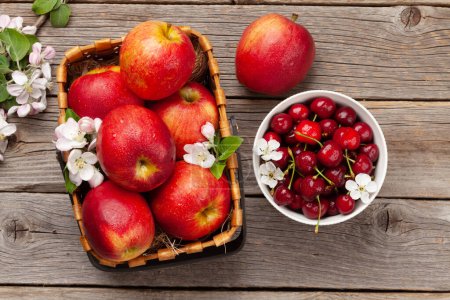 Photo for Ripe red apples and cherry on wooden table. Top view flat lay - Royalty Free Image