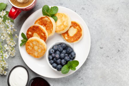 Photo for Cottage pancakes with berry jam, sour cream and berries. Breakfast with coffee. Top view flat lay with copy space - Royalty Free Image