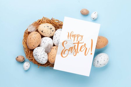 Téléchargez les photos : Carte de vœux de Pâques sur les œufs de Pâques dans le nid. Vue du dessus plat avec espace de copie - en image libre de droit