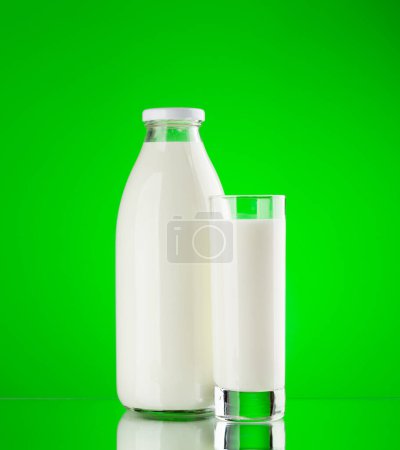 Téléchargez les photos : Bouteille de lait et verre sur fond vert. Produits laitiers - en image libre de droit