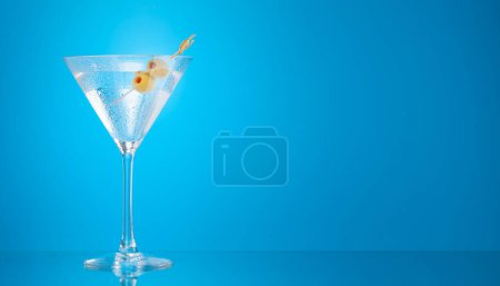 Téléchargez les photos : Martini cocktail sur fond bleu avec espace de copie - en image libre de droit