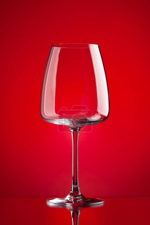 Téléchargez les photos : Verre à vin rouge sur fond rouge - en image libre de droit