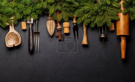 Foto de Utensilios de cocina y ramas de abeto en la mesa de cocina. Concepto de cocina navideña. Piso con espacio de copia - Imagen libre de derechos