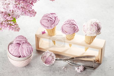 Photo for Berry ice cream sundae in waffle cones and lilac flowers - Royalty Free Image