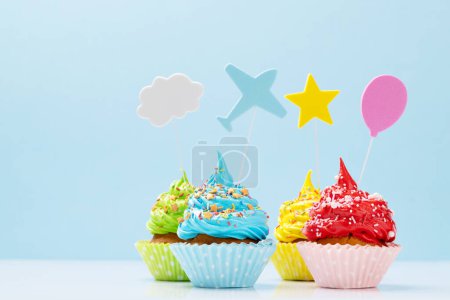 Foto de Coloridos cupcakes sobre fondo azul con espacio para copiar - Imagen libre de derechos