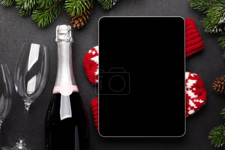 Téléchargez les photos : Tablette avec écran vierge, champagne et décor de Noël. Modèle d'écran de périphérique de Noël - en image libre de droit