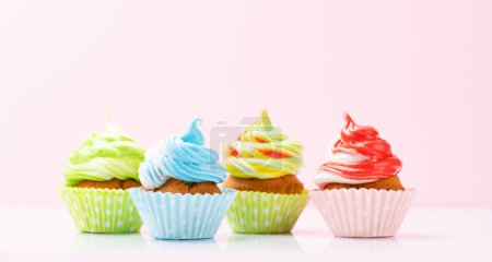 Téléchargez les photos : Cupcakes colorés sur fond rose avec espace de copie - en image libre de droit