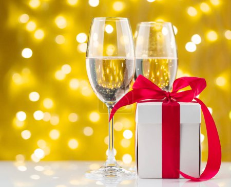 Téléchargez les photos : Champagne verres et coffret cadeau devant les lumières de Noël bokeh - en image libre de droit