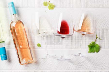 Téléchargez les photos : Verres et bouteilles de vin blanc, rose et rouge. Pose plate - en image libre de droit
