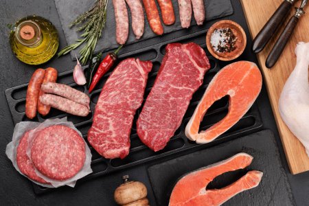 Téléchargez les photos : Viande et poisson crus divers. Steaks, saucisses, saumon et épices. Pose plate - en image libre de droit
