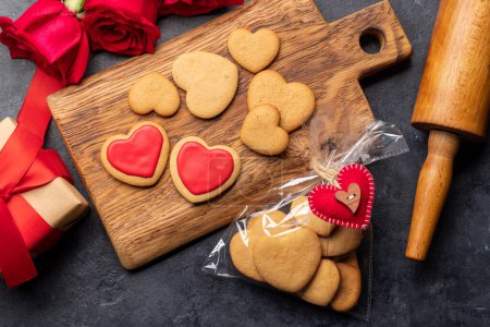 Téléchargez les photos : Carte Saint-Valentin avec biscuits en forme de coeur, fleurs roses et coffret cadeau. Pose plate - en image libre de droit