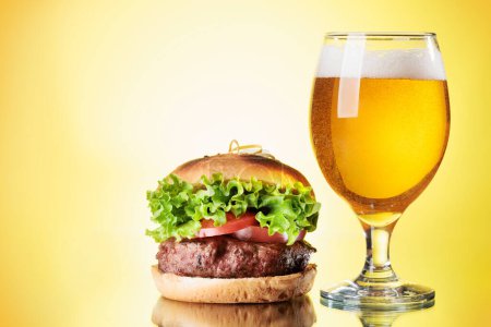Téléchargez les photos : Verre à bière et hamburger sur fond de couleur - en image libre de droit