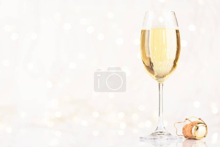 Photo for Champagne glass in front of Christmas lights bokeh with copy space for your Xmas greetings - Royalty Free Image