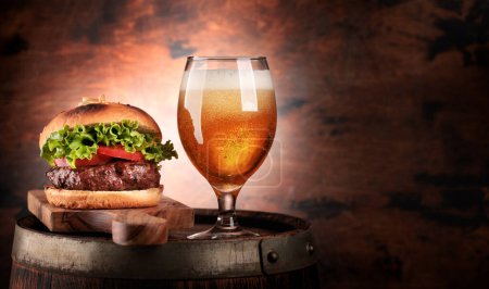 Photo for Draft beer glass and hamburger on wooden barrel. With copy space - Royalty Free Image