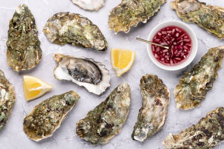 Photo for Fresh oysters with sauce and lemons. Flat lay - Royalty Free Image