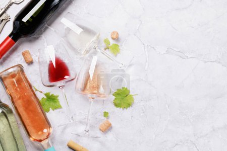 Foto de Botellas y vasos de vino blanco, rosa y tinto. Piso con espacio de copia - Imagen libre de derechos