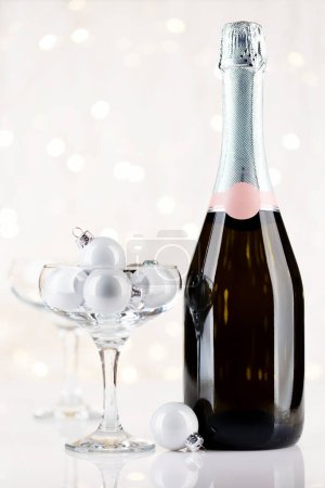 Foto de Botella de champán y copas con decoración de Navidad frente a las luces de Navidad bokeh - Imagen libre de derechos