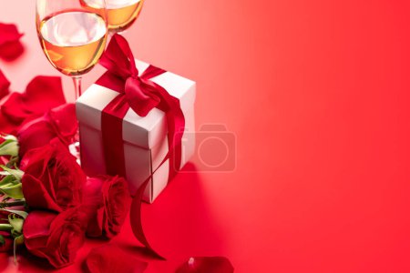 Photo for Valentines day card with champagne, rose flowers and gift box. On red background with space for your greetings - Royalty Free Image