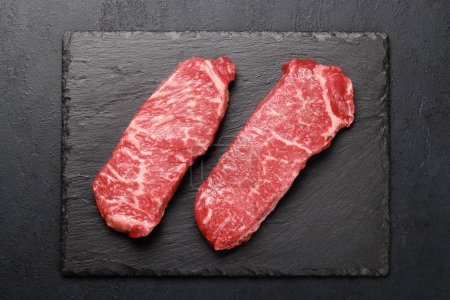 Téléchargez les photos : Des steaks de bœuf marbrés. Bifteck de striploïne cru. Pose plate - en image libre de droit