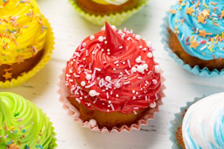 Foto de Cupcakes coloridos en mesa de madera - Imagen libre de derechos