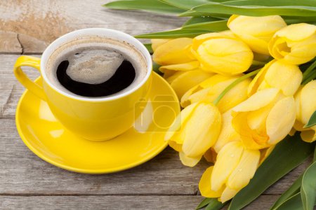 Téléchargez les photos : Tulipes jaunes et tasse à café sur table en bois - en image libre de droit