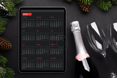 Foto de Tableta con calendario, champán y decoración navideña. plantilla de pantalla de dispositivo de Navidad - Imagen libre de derechos