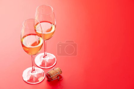 Téléchargez les photos : Carte Saint Valentin avec deux verres de champagne et bouchon de champagne. Sur fond rouge avec espace pour vos salutations - en image libre de droit