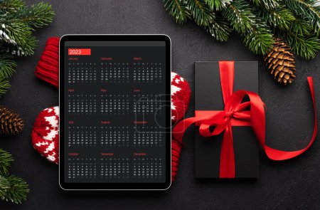 Photo for Tablet with calendar, gift box and Christmas decor. Xmas device screen template - Royalty Free Image