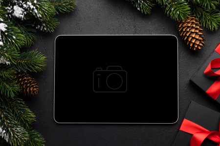 Téléchargez les photos : Tablette avec écran vierge, coffrets cadeaux et décor de Noël. Modèle d'écran de périphérique de Noël - en image libre de droit