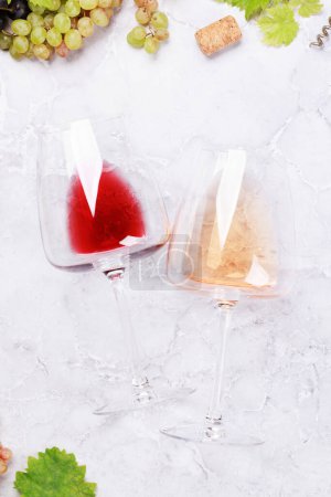 Téléchargez les photos : Verres à vin rose et rouge et raisin. Pose plate - en image libre de droit