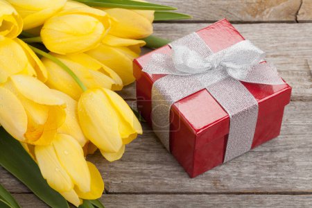 Photo for Yellow tulips and gift box on wooden table - Royalty Free Image