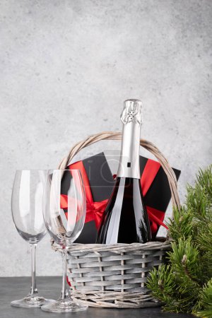 Téléchargez les photos : Panier avec coffrets cadeaux de Noël et champagne. Avec espace pour les salutations de Noël - en image libre de droit