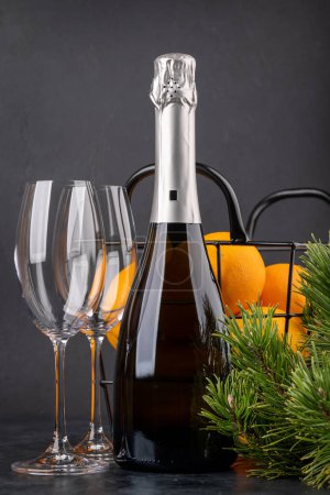 Téléchargez les photos : Panier avec oranges, champagne et branche de sapin. Cadeau de Noël - en image libre de droit