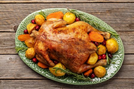 Téléchargez les photos : Dinde de Thanksgiving avec pommes de terre et carotte sur table rustique. Pose plate - en image libre de droit