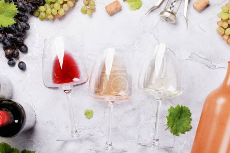Foto de Copas y botellas de vino blanco, rosa y tinto. Puesta plana - Imagen libre de derechos