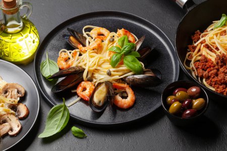 Téléchargez les photos : Différentes pâtes italiennes. Pâtes à la sauce aux fruits de mer, champignons et tomates, spaghettis bolognais - en image libre de droit
