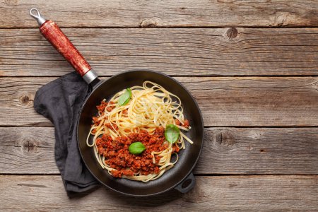 Téléchargez les photos : Des spaghettis bolognais. Pâtes avec sauce tomate et viande hachée. Vue du dessus plat avec espace de copie - en image libre de droit