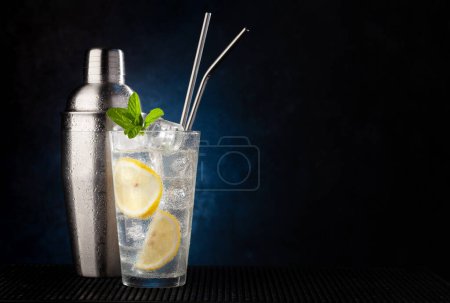 Téléchargez les photos : Cocktail shaker et gin tonic cocktail sur fond sombre avec espace de copie - en image libre de droit