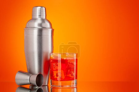 Téléchargez les photos : Cocktail shaker et negroni cocktail sur fond orange avec espace de copie - en image libre de droit