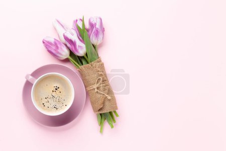 Foto de Ramo de flores de tulipán púrpura y taza de café sobre fondo rosa. Piso con espacio de copia - Imagen libre de derechos